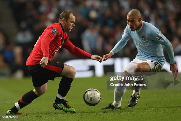 Wayne Rooney of Manchester United clashes with Nigel De Jong of Manchester City during the Carling Cup Semi-Final First Leg match between Manchester...