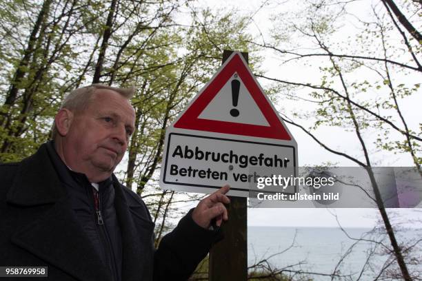 Der Landwirtschaftsminister Mecklenburg-Vorpommerns Till Backhaus steht an einem Warnschild "Abbruchgefahr - Betreten verboten"an der Kreidekueste...