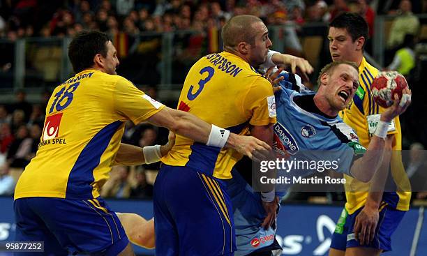 Tobias Karlsson and Mattias Gustafsson of Sweden in action with Miha Zvizej of Slovenia during the Men's Handball European Championship Group C match...