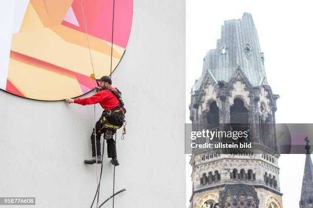 Deutschland Germany Berlin Ein Arbeiter entfernt die Aussenwerbung für eine Frühlingsinstallation im Bikini-Haus.