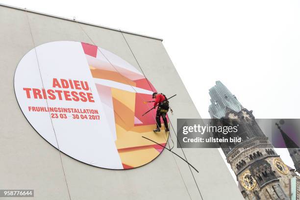 Deutschland Germany Berlin Ein Arbeiter entfernt die Aussenwerbung für eine Frühlingsinstallation im Bikini-Haus.