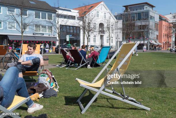 Jugendliche "chillen" auf Liegestühlen, die die Kaufmannschaft der umliegenden Geschäfte auf einem Platz in der Innenstadt aufgestellt hat