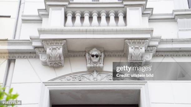 Putto-Figur mit Sonnenbrille an einer Altbau-Hauswand im Viertel in Bremen