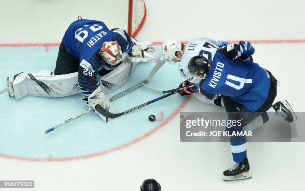 Anders Lee of the United States challenges for the puck with Finland's Tommi Koivisto and Finland's goalkeeper Harri Sateri during the group B match...