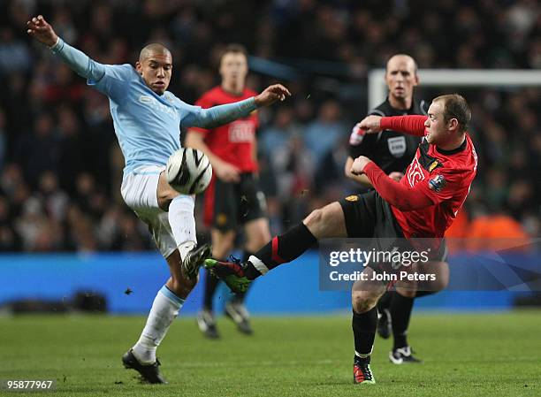 Wayne Rooney of Manchester United clashes with Nigel De Jong of Manchester City during the Carling Cup Semi-Final First Leg match between Manchester...