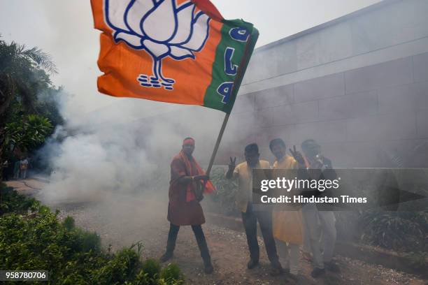 Bharatiya Janata Party activists and workers celebrate party's lead in the Karnataka assembly elections outside party headquarters at Deendayal...