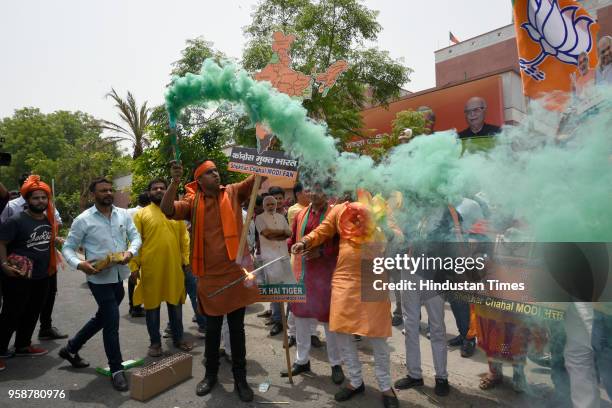 Bharatiya Janata Party activists and workers celebrate party's lead in the Karnataka assembly elections outside party headquarters at Deendayal...