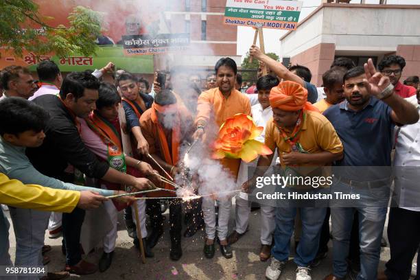 Bharatiya Janata Party activists and workers celebrate party's lead in Karnataka elections by bursting crackers outside BJP headquarters, at Deen...