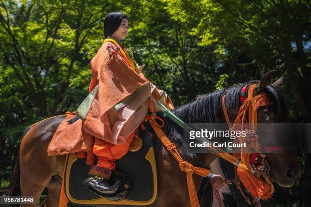 Woman rides a horse in Heian period dress during the Aoi Festival on May 15, 2018 in Kyoto, Japan. Aoi Festival is one of the three main festivals of...
