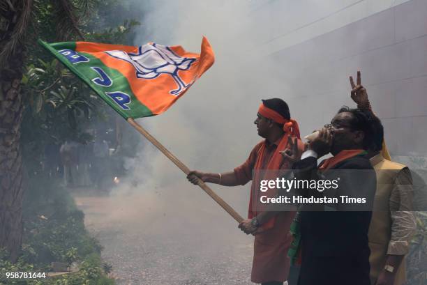 Bharatiya Janata Party activists and workers celebrate party's lead in Karnataka elections by bursting crackers outside BJP headquarters, at Deen...