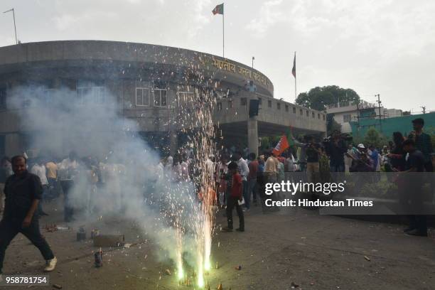 Workers burst crackers to celebrate party's lead in Karnataka elections at state BJP headquarters on May 15, 2018 in Bhopal, India. Out of 222 seats...