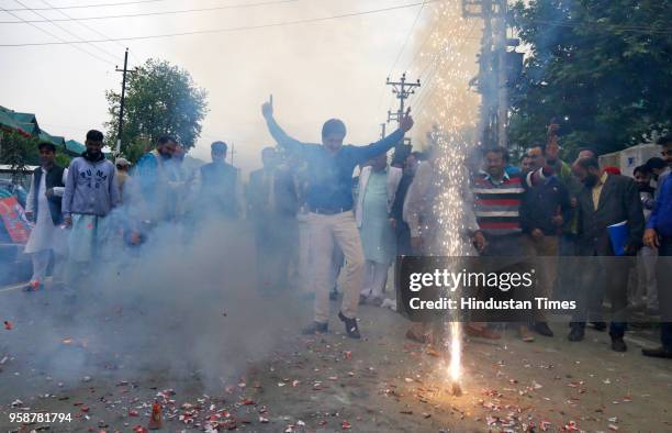 Workers from the ruling Bharatiya Janata Party burst fire crackers to celebrate party's lead in Karnataka elections outside the BJP office on May 15,...