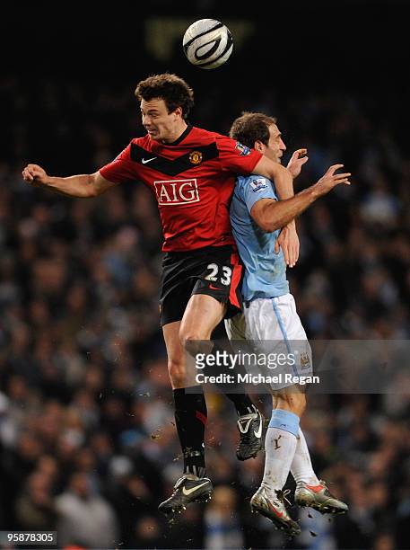 Pablo Zabaleta of Manchester City leaps for the ball with Jonny Evans of Manchester United during the Carling Cup Semi Final match between Manchester...