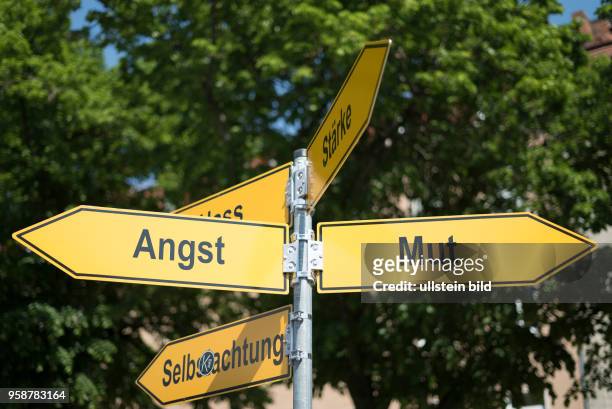 Symbolbild: Die Begriffe Angst, Mut, Stärke, Selbstachtung stehen auf Wegweisern in Bayreuth