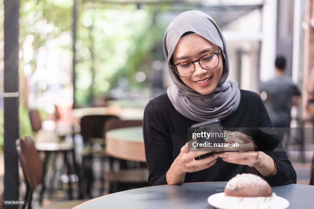 Muslim girl during lunch break checking email.