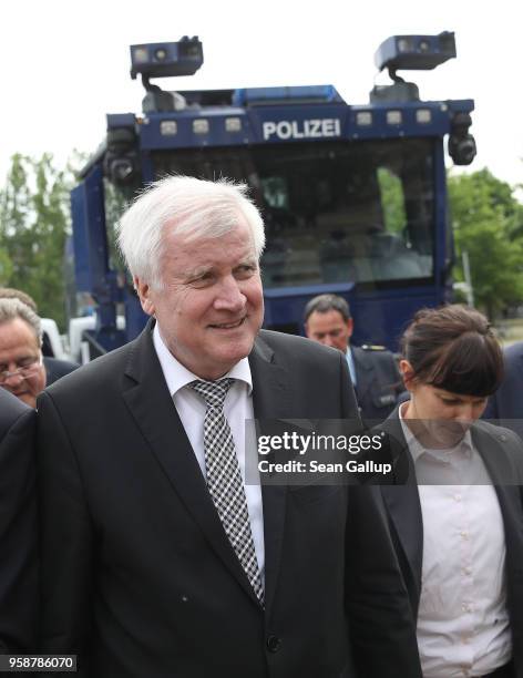 German Interior Minister Horst Seehofer walks past a police water cannon during a visit to the German Federal Police headquarters on May 15, 2018 in...