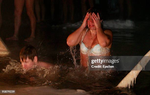 Russian Orthodox believers plunge in the icy waters of a Moscow pond in celebration of the Epiphany holiday early on January 19, 2010 in Moscow,...