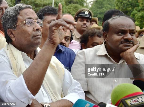 Outgoing Chief Minister of Karnataka Siddaramaiah gestures while Janatha Dal State President H.D Kumaraswamy looks on as they address media after...