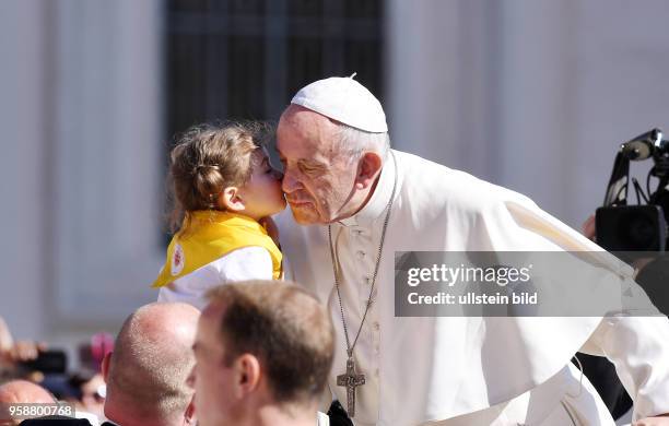 Rom, Vatikan Papst Franziskus I. Kuesst und segnet ein Kind bei der woechentlichen Generalaudienz auf dem Petersplatz