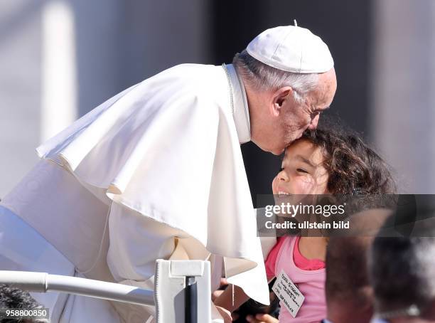 Rom, Vatikan Papst Franziskus I. Kuesst und segnet ein Kind bei der woechentlichen Generalaudienz auf dem Petersplatz