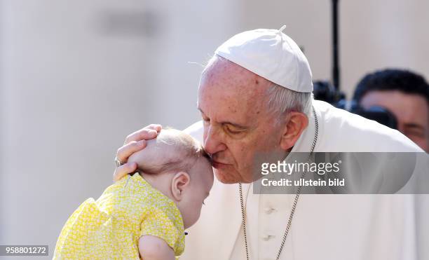 Rom, Vatikan Papst Franziskus I. Kuesst und segnet ein Baby bei der woechentlichen Generalaudienz auf dem Petersplatz