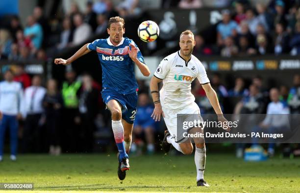 Stoke City's Peter Crouch and Swansea City's Mike van der Hoorn battle for the ball during the Premier League match at the Liberty Stadium, Swansea