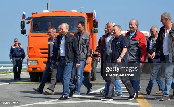 Russian President Vladimir Putin meets with workers during an opening ceremony of the road section of the Krymsky Bridge over the Kerch Strait, in...