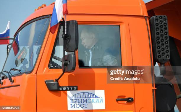 Russian President Vladimir Putin drives a KamAZ truck at the head of a truck convoy crossing the road-and-rail Krymsky Bridge over the Kerch Strait,...