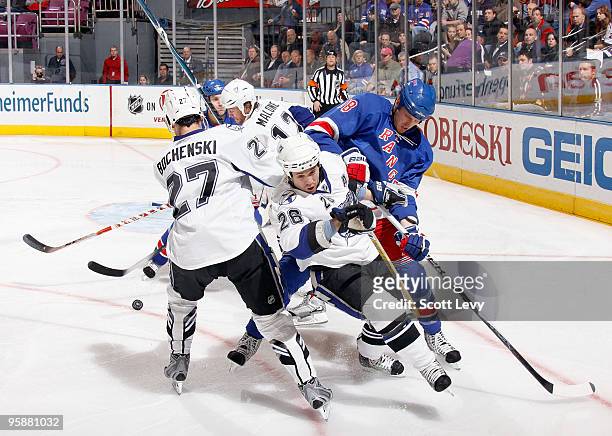 Marc Staal and Michael Del Zotto of the New York Rangers battle for the puck against Ryan Malone, Brandon Bochenski, and Martin St.Louis of the Tampa...
