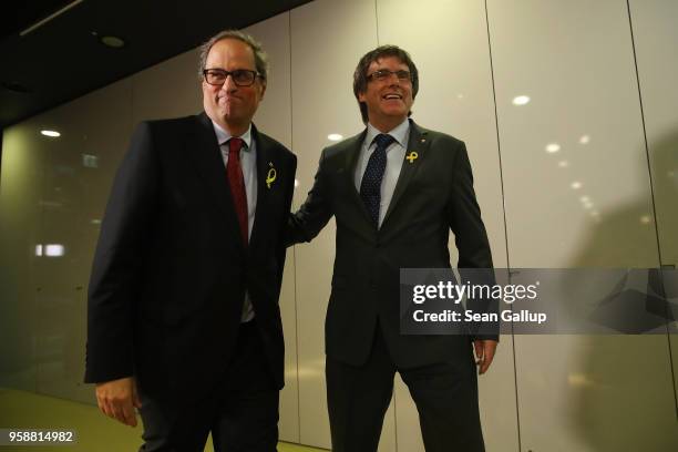 Former Catalan separitist leader Carles Puigdemont and newly-elected Catalan leader Quim Torra depart after speaking to the media on May 15, 2018 in...