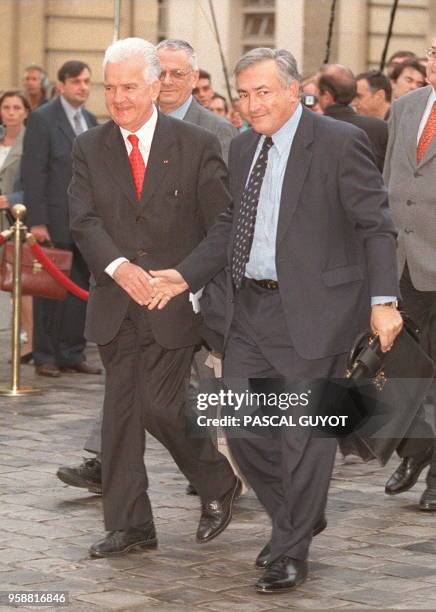 Dominique Strauss-Kahn, ministre de l'Economie serre la main de Lucien Rebuffel, président de la CGPME, alors qu'ils arrivent, le 10 octobre à...
