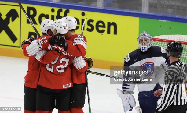 Enzo Corvi of Switzerland celebrate his goal with teammates and Florian Hardy of France is disapointed during the 2018 IIHF Ice Hockey World...