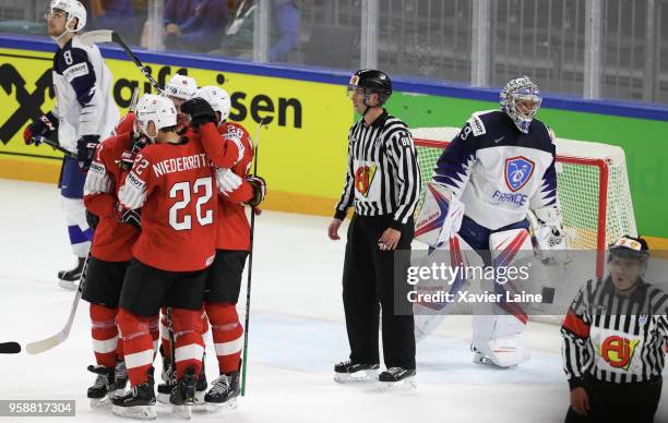 Enzo Corvi of Switzerland celebrate his goal with teammates and Florian Hardy of France is disapointed during the 2018 IIHF Ice Hockey World...