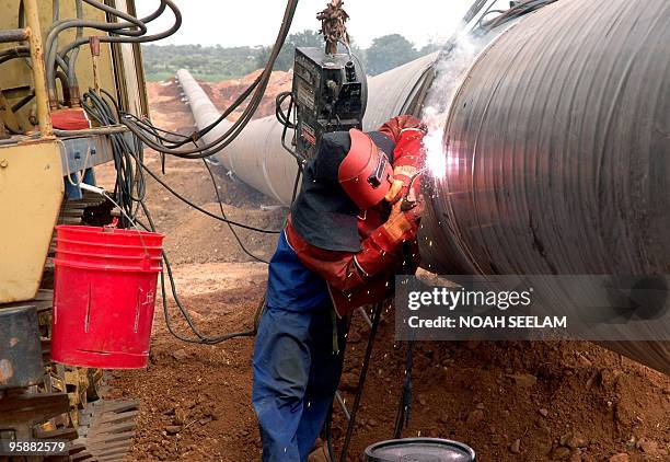 In this file photograph taken on July 13, 2007 engineers from China Petroleum Pipeline Material and Equipment Corporation weld carbon steel pipes as...