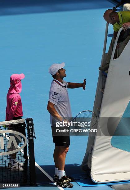 Tennis player Andy Roddick speaks with the umpire during his men's singles match against Brazilian opponent Thomaz Bellucci on the third day of play...