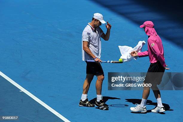 Tennis player Andy Roddick gives his towel to a ballboy during his men's singles match against Brazilian opponent Thomaz Bellucci on the third day of...