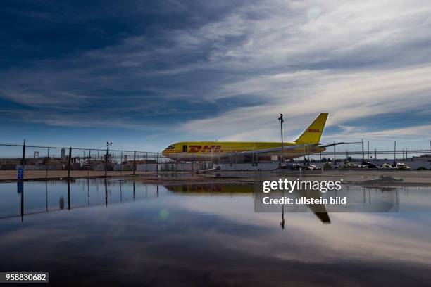 Reflection of a DHL cargo jet in a puddle at San Diego International Airport.