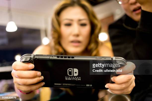 Woman playing with a Nintendo Switch video game console.