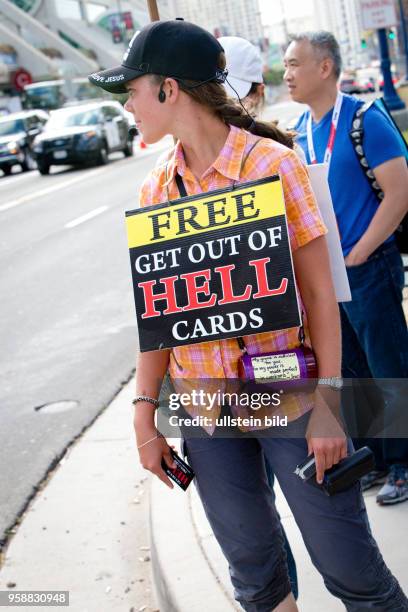 Woman handing out free "Get out of hell" cards at the Comic-Con.