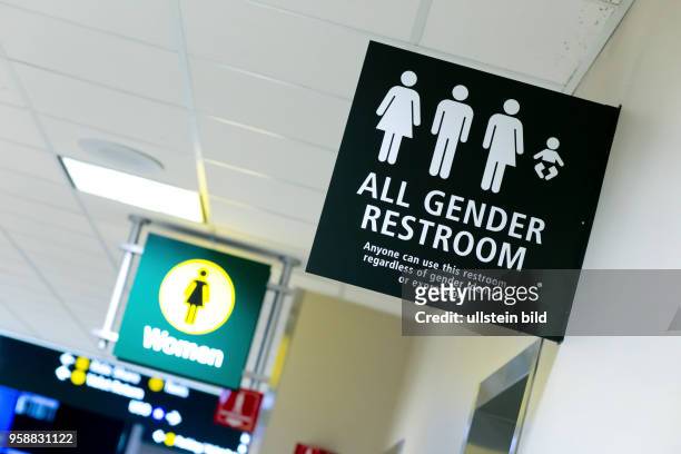 All Gender Restroom at San Diego Airport, next to a women's restroom sign.