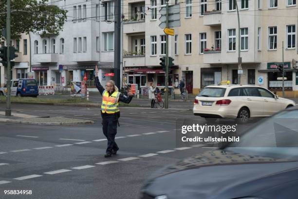 Polizeibeamte regelt den Verkher auf der Kreuzung Greifswalder Strassee / Danziger Strasse in Berlin-Prenzlauer Berg