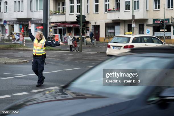 Polizeibeamte regelt den Verkher auf der Kreuzung Greifswalder Strassee / Danziger Strasse in Berlin-Prenzlauer Berg