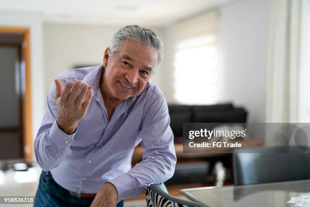 reifer mann tanzen und freundliches zu hause seine haustür öffnen - heranlocken stock-fotos und bilder