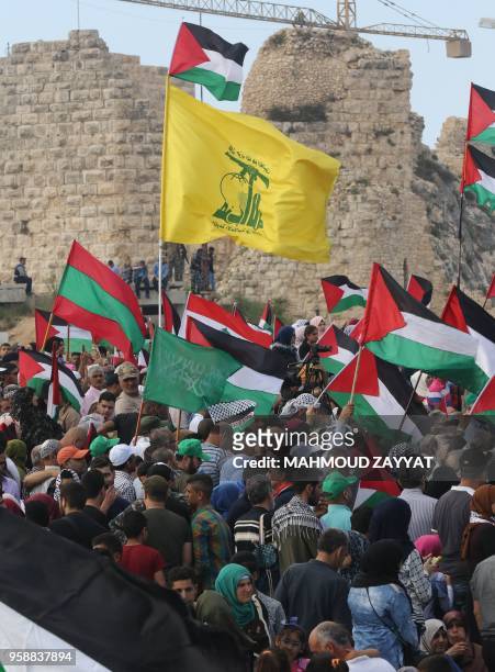 Protesters including Lebanese nationals and Palestinian refugees living in Lebanon wave a flag of Hezbollah along with the flags of Palestine,...