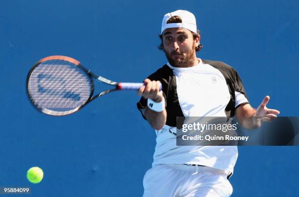 Santiago Ventura of Spain plays a forehand in his first round doubles match with Marc Lopez of Spain against Jurgen Melzer of Austria and Philipp...