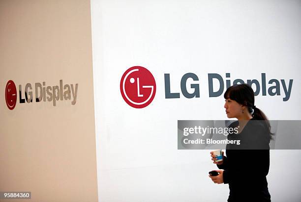 Jo Seon-ji, an LG Display Co. Employee, walks past company's logo at the venue where the company held a news conference announcing third quarter...