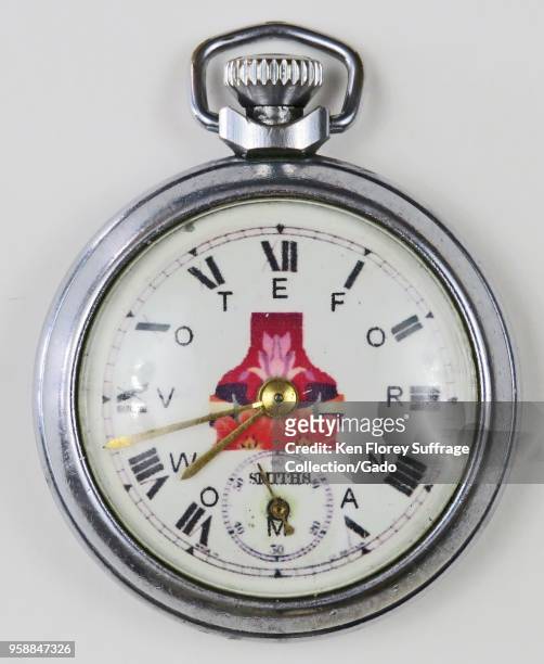 Silver-colored, pro-suffrage pocket watch or fob watch, with the phrase "Vote for Woman, ” with each letter corresponding to a Roman numeral, and a...