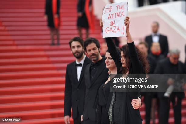 French-Lebanese actress Manal Issa holds a sign reading "Stop the Attack on Gaza" as she arrives on May 15, 2018 with Syrian director Gaya Jiji and...
