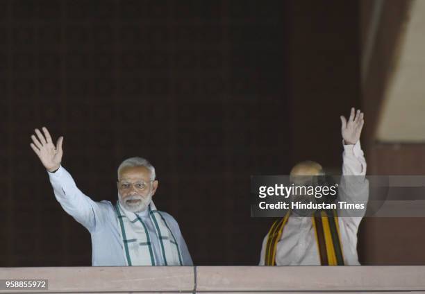 Prime Minister Narendra Modi and BJP President Amit Shah wave to workers at the party headquarter after BJP emerged as the single largest party in...