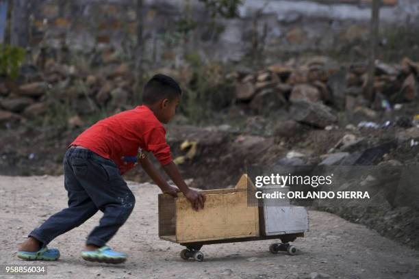 Boy plays in the poor neighbourhood of Nueva Capital, on the outskirts of Tegucigalpa, on May 13, 2018. - Missionaries from the United States who met...